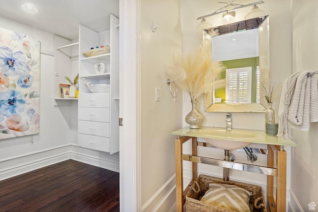 bathroom with wood finished floors, a sink, and baseboards