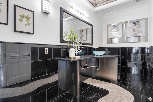 bathroom with tile walls, wainscoting, granite tiled floors, vanity, and crown molding