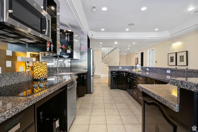 kitchen with stainless steel appliances, a sink, backsplash, light tile patterned flooring, and recessed lighting