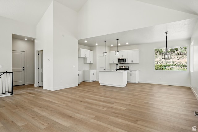 732 S Liberty Dr S, Cedar City, UT 84720 - unfurnished living room with light wood-style flooring, baseboards, a high ceiling, a sink, and recessed lighting