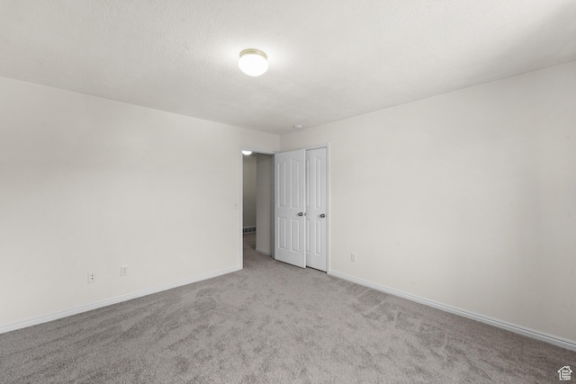 carpeted empty room with baseboards