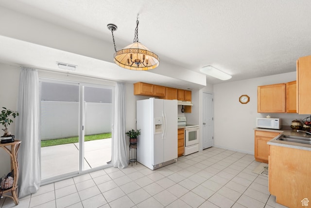 kitchen with white appliances, a sink, under cabinet range hood, light brown cabinets, and hanging light fixtures