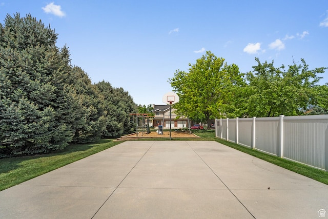 view of patio / terrace with basketball court and fence