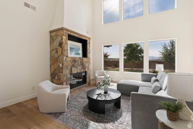 3134 S 355 W, Washington, UT 84780 - living area with a stone fireplace, wood finished floors, baseboards, plenty of natural light, and a high ceiling