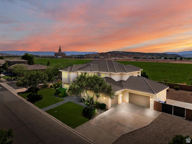 3134 S 355 W, Washington, UT 84780 - view of front of home with an attached garage, driveway, stucco siding, a tile roof, and a view of rural / pastoral area