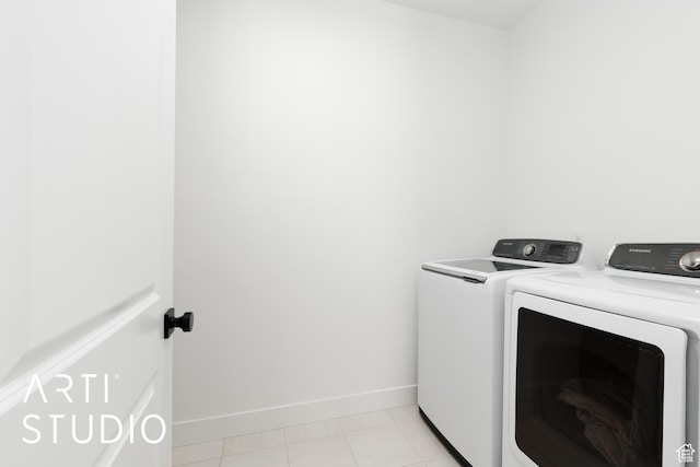 clothes washing area with washing machine and clothes dryer and baseboards