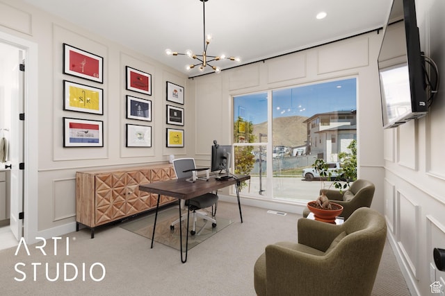 office with a decorative wall, light colored carpet, and a chandelier