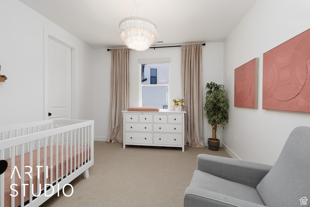 carpeted bedroom with a chandelier, a nursery area, and baseboards