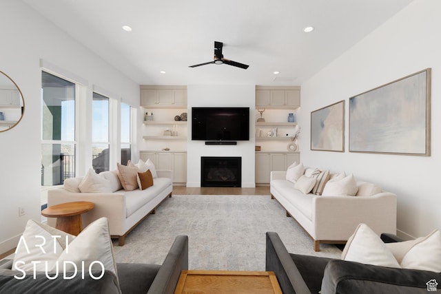 living area with ceiling fan, recessed lighting, light wood finished floors, and a fireplace