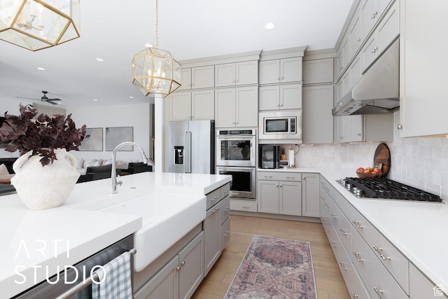 kitchen featuring stainless steel appliances, gray cabinetry, a sink, recessed lighting, and tasteful backsplash