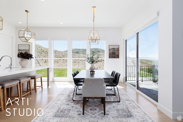dining area featuring a chandelier, light wood-style floors, and recessed lighting