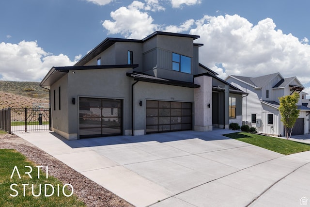 contemporary home with fence, concrete driveway, and stucco siding