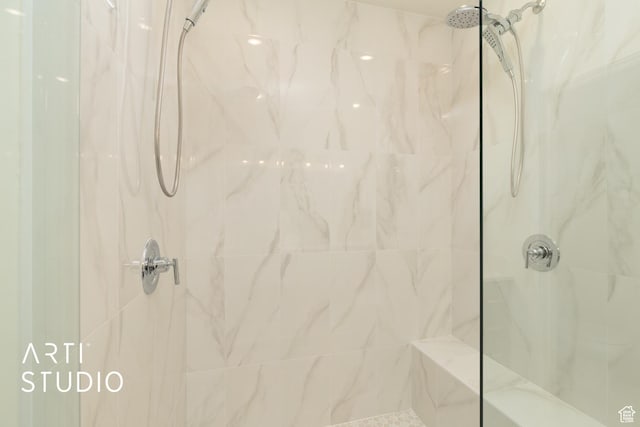 bathroom featuring a marble finish shower