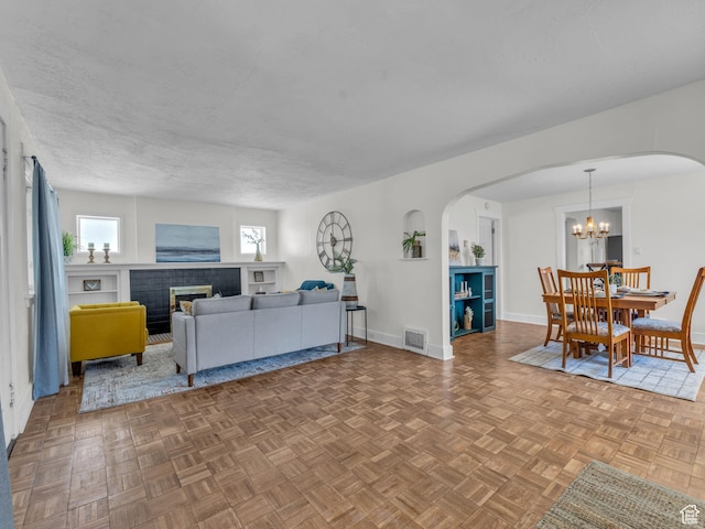 2829 S 900 E, Millcreek, UT 84106 - living area with arched walkways, baseboards, a chandelier, and a fireplace
