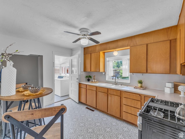 2829 S 900 E, Millcreek, UT 84106 - kitchen with a sink, washer / clothes dryer, light countertops, ceiling fan, and gas stove