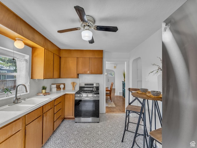 2829 S 900 E, Millcreek, UT 84106 - kitchen with gas range, a sink, light countertops, arched walkways, and a ceiling fan