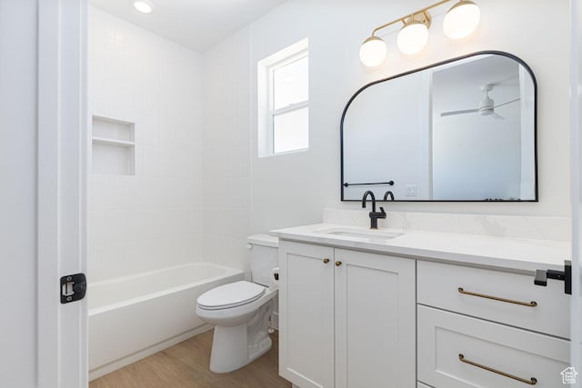 full bathroom with wood finished floors, toilet, vanity, and shower / tub combination