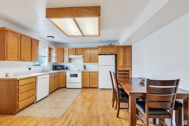 kitchen with white appliances, a sink, light countertops, open shelves, and light wood-style flooring