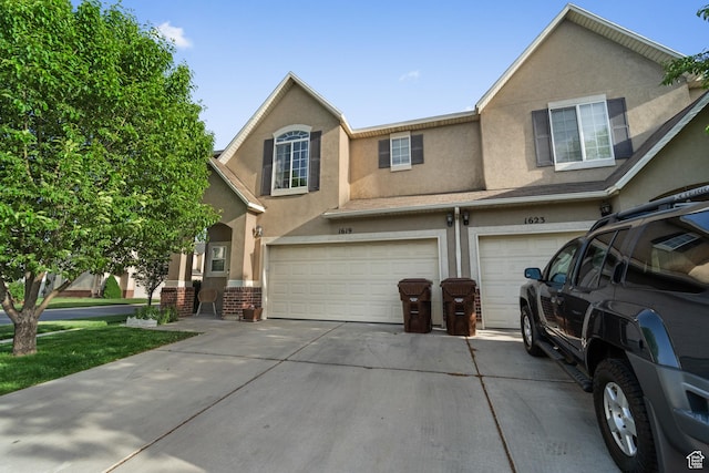 1619 W Little Oak Ct, West Valley City, UT 84119 - view of property with a garage, stucco siding, concrete driveway, and brick siding