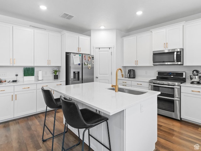 826 W 700 S, American Fork, UT 84003 - kitchen featuring appliances with stainless steel finishes, a sink, white cabinetry, a breakfast bar area, and light countertops