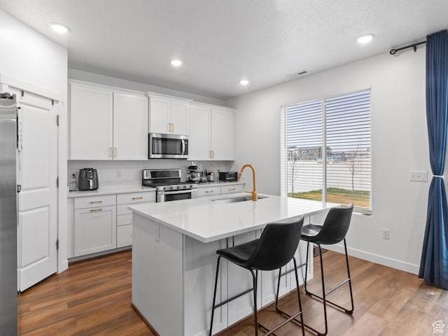 826 W 700 S, American Fork, UT 84003 - kitchen with stainless steel appliances, a sink, white cabinetry, a kitchen bar, and light countertops