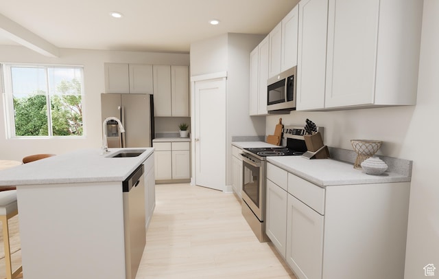 1345 N 1390 E Unit 22-105, Payson, UT 84651 - kitchen with appliances with stainless steel finishes, a sink, light wood-type flooring, a center island with sink, and light countertops