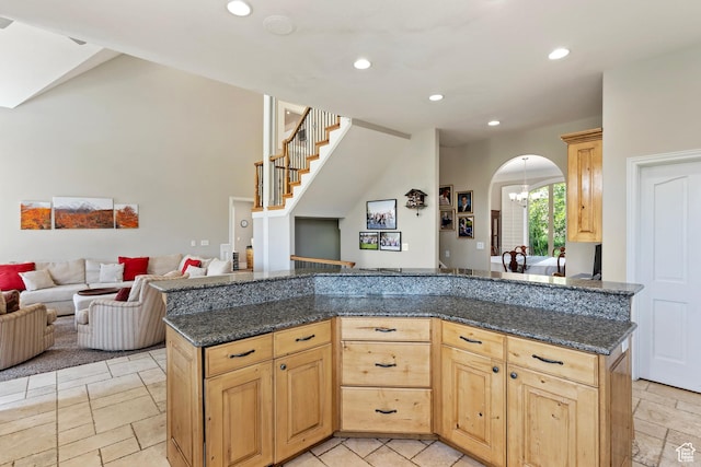 2333 S Falcon Way, Huntsville, UT 84317 - kitchen with arched walkways, open floor plan, recessed lighting, light brown cabinetry, and dark stone counters