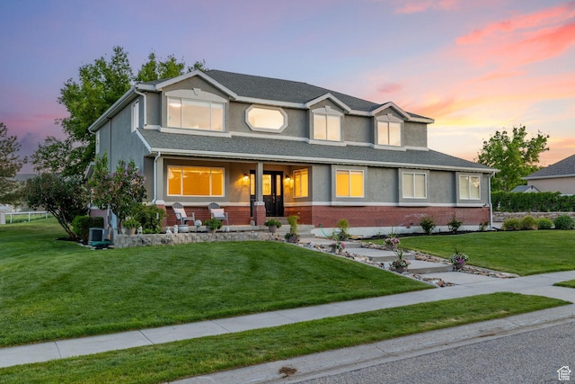 2859 W Country Classic Dr, Bluffdale, UT 84065 - view of front of house with covered porch, a yard, stucco siding, and brick siding