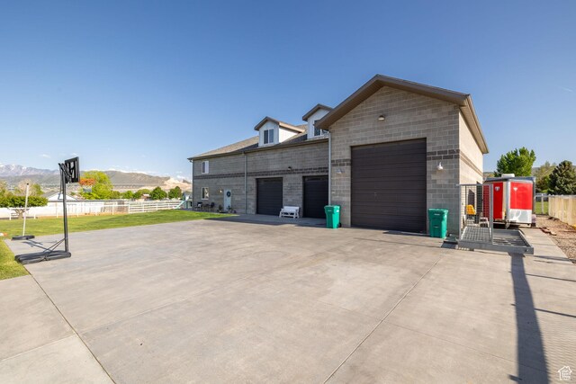 2859 W Country Classic Dr, Bluffdale, UT 84065 - view of side of property with fence, a mountain view, an attached garage, and concrete driveway
