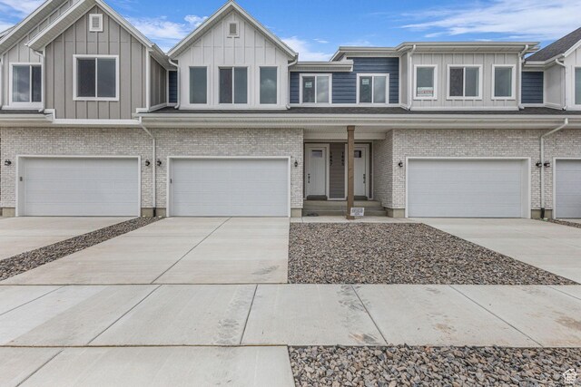 1667 W 2770 S Unit 206, Syracuse, UT 84075 - view of front of home with board and batten siding, a garage, and driveway