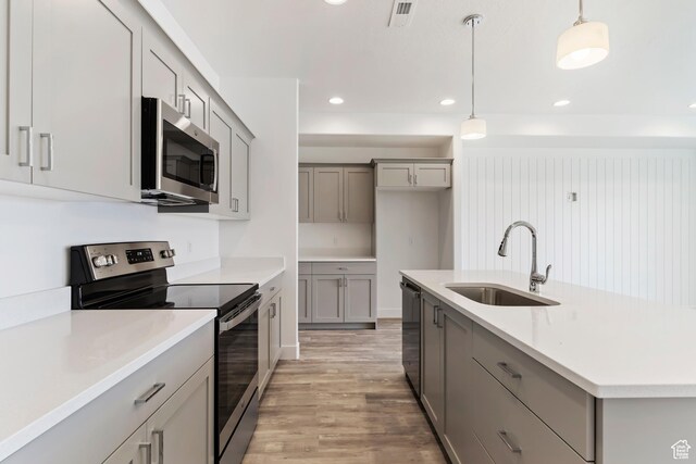 1667 W 2770 S Unit 206, Syracuse, UT 84075 - kitchen with appliances with stainless steel finishes, gray cabinetry, a sink, light wood-style flooring, and pendant lighting