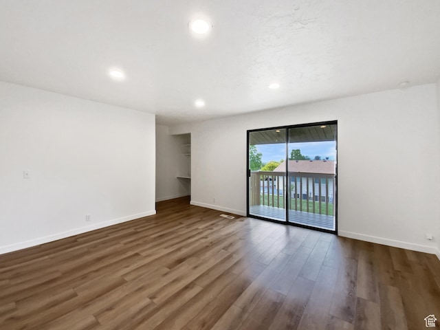 spare room featuring dark wood-type flooring, baseboards, and recessed lighting