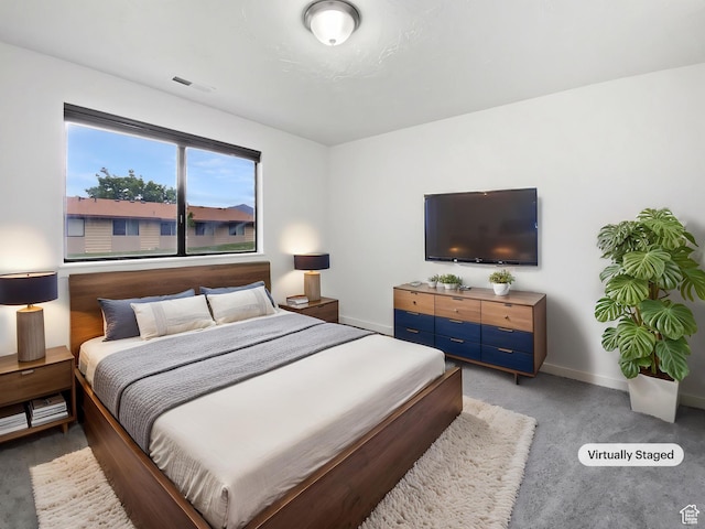 bedroom with light colored carpet and baseboards