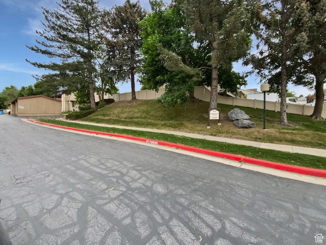 view of asphalt road with sidewalks, curbs, and street lights
