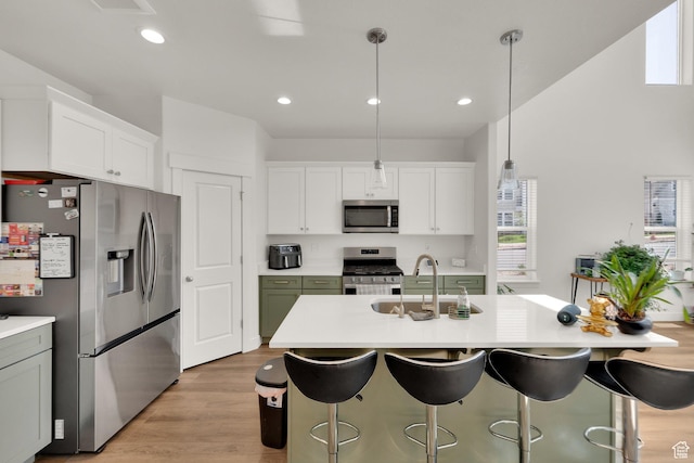 1293 N 3960 W Unit 457, Lehi, UT 84043 - kitchen with stainless steel appliances, a sink, light countertops, a breakfast bar area, and white cabinetry