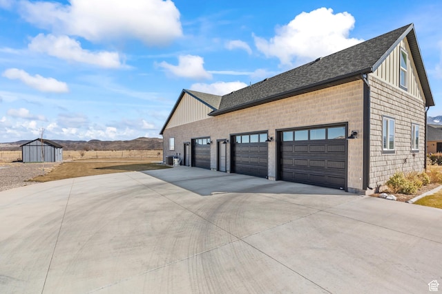 2201 S 380 W, Richfield, UT 84701 - view of home's exterior with concrete driveway, roof with shingles, an attached garage, and a shed
