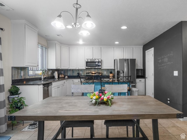 920 W Stonehaven Dr, North Salt Lake, UT 84054 - kitchen with appliances with stainless steel finishes, a sink, light tile patterned flooring, dark countertops, and white cabinets