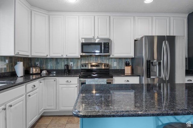 920 W Stonehaven Dr, North Salt Lake, UT 84054 - kitchen with stainless steel appliances, white cabinets, light tile patterned flooring, and dark stone counters