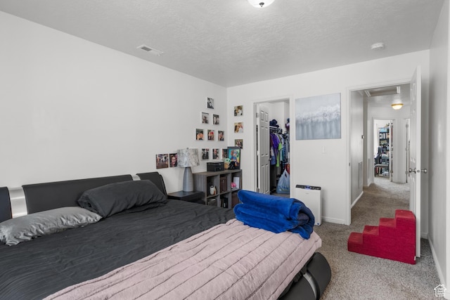 920 W Stonehaven Dr, North Salt Lake, UT 84054 - bedroom with carpet, attic access, a walk in closet, a textured ceiling, and baseboards