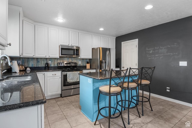 920 W Stonehaven Dr, North Salt Lake, UT 84054 - kitchen featuring appliances with stainless steel finishes, a sink, white cabinetry, a kitchen island, and light tile patterned flooring
