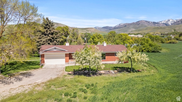3647 Maple Creek Rd N, Franklin, ID 83237 - view of front of home featuring driveway, an attached garage, a front lawn, and a mountain view