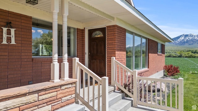 3647 Maple Creek Rd N, Franklin, ID 83237 - view of exterior entry with brick siding, a porch, and a mountain view