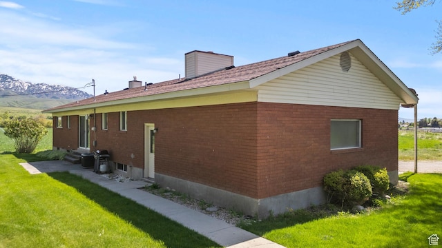 3647 Maple Creek Rd N, Franklin, ID 83237 - view of side of property featuring entry steps, brick siding, a lawn, and a chimney
