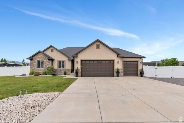 1565 E Smithfield Dr, Eagle Mountain, UT 84005 - view of front of home featuring stucco siding, stone siding, an attached garage, driveway, and a gate