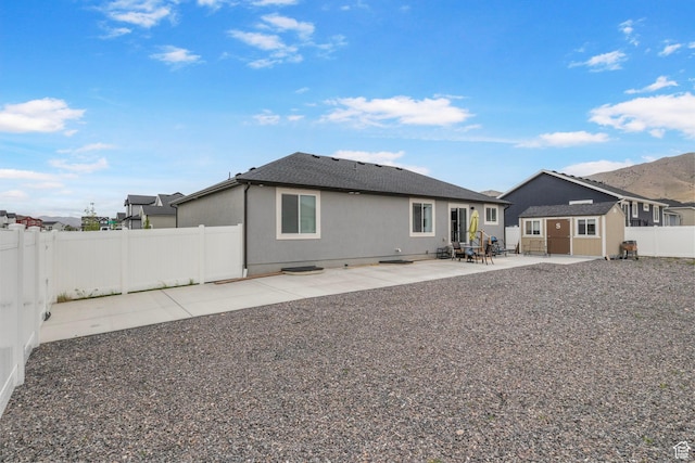 2256 E Boxwood Ln, Eagle Mountain, UT 84005 - rear view of property featuring a patio, a fenced backyard, stucco siding, and a shingled roof