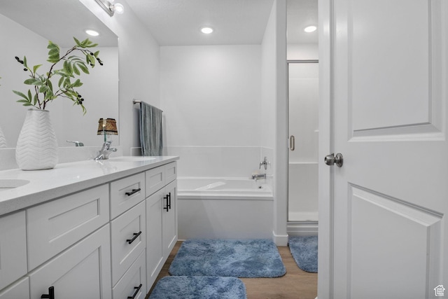2256 E Boxwood Ln, Eagle Mountain, UT 84005 - bathroom with a stall shower, wood finished floors, a garden tub, double vanity, and recessed lighting