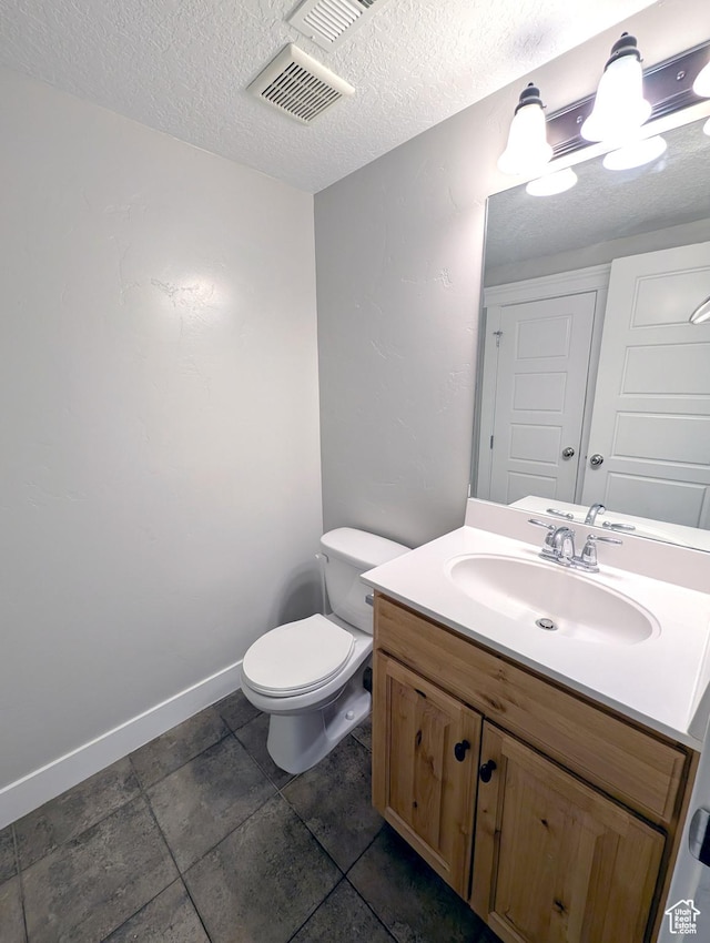 266 W 1010 S, Logan, UT 84321 - bathroom featuring toilet, vanity, a textured ceiling, and baseboards