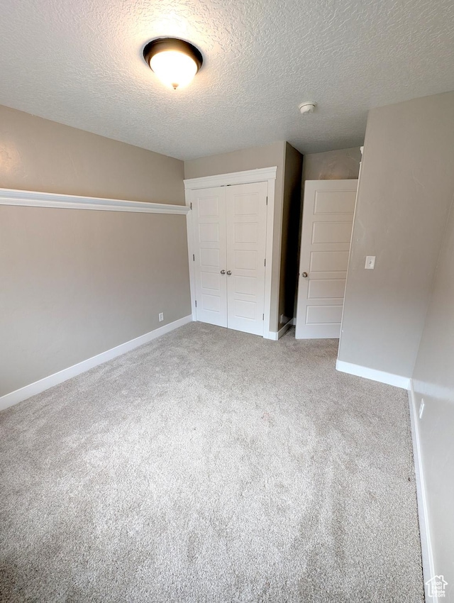 266 W 1010 S, Logan, UT 84321 - unfurnished bedroom with a closet, carpet floors, a textured ceiling, and baseboards