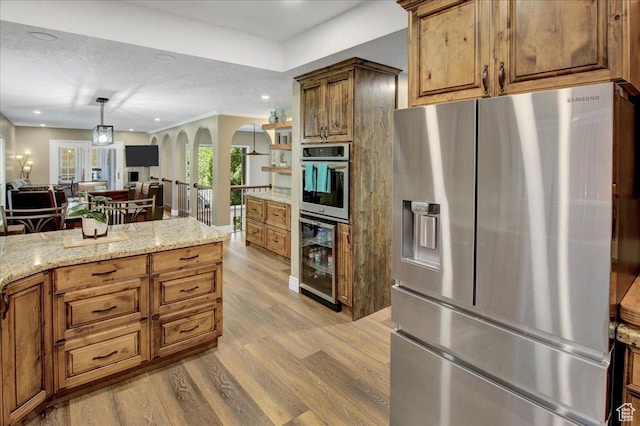875 E Burch Creek Holw S, South Ogden, UT 84403 - kitchen with stainless steel appliances, beverage cooler, arched walkways, wood finished floors, and brown cabinetry