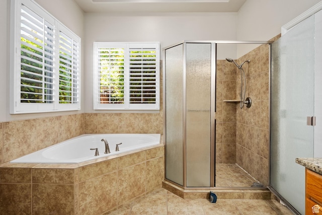 full bath featuring a stall shower, a garden tub, vanity, and tile patterned flooring